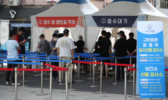 국내 코로나19 확산세가 점점 거세지면서 신규 확진자 수가 결국 1600명 선도 넘어선 14일 서울 도봉구 창동역 임시 선별검사소에서 시민들이 검사를 기다리고 있다. <연합뉴스>